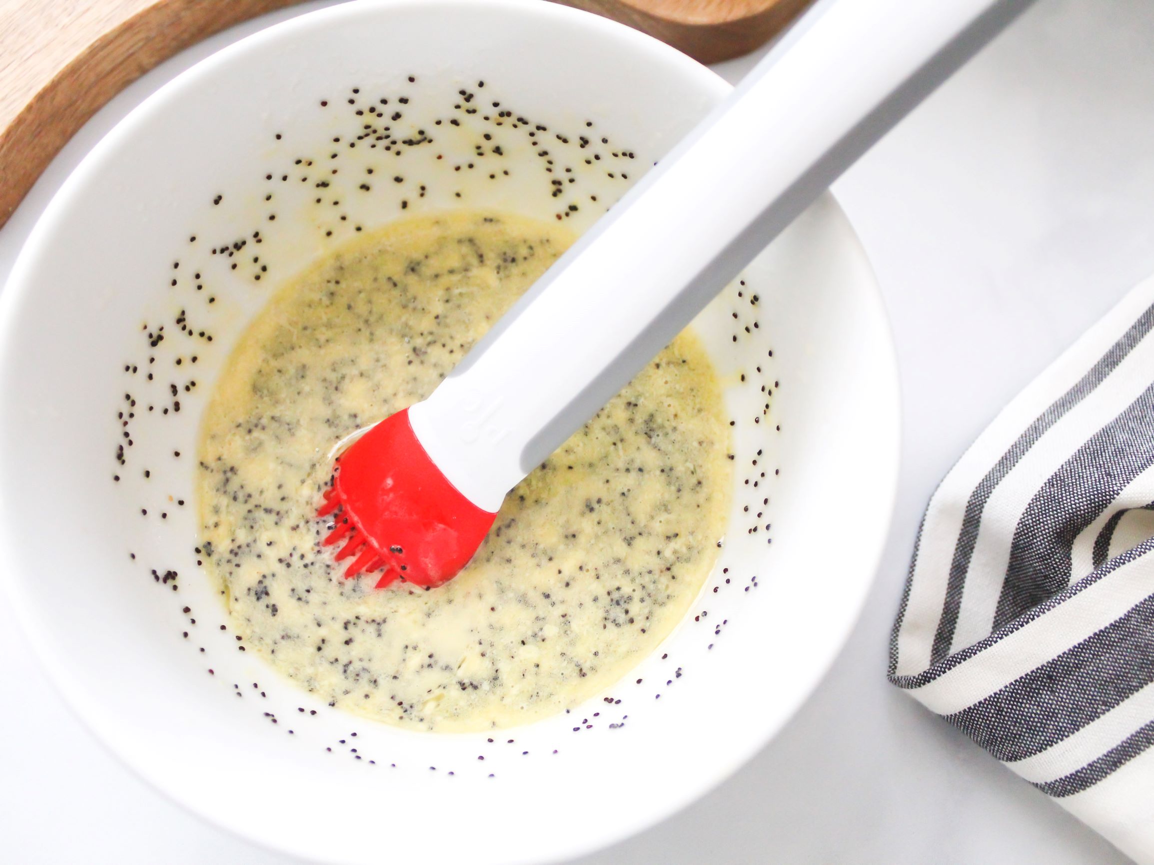 Bowl with slider sauce mix made of melted butter, honey mustard sauce and poppy seeds