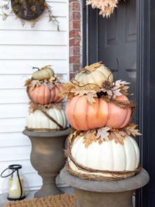 DIY Faux Stacked Pumpkin Topiaries Displayed in Urns on a Front Porch for Fall