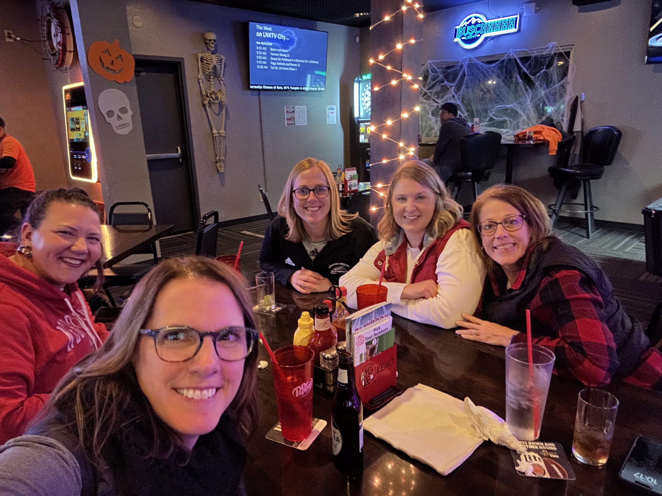 Group of adult women friends smiling for a photo while out for dinner and drinks