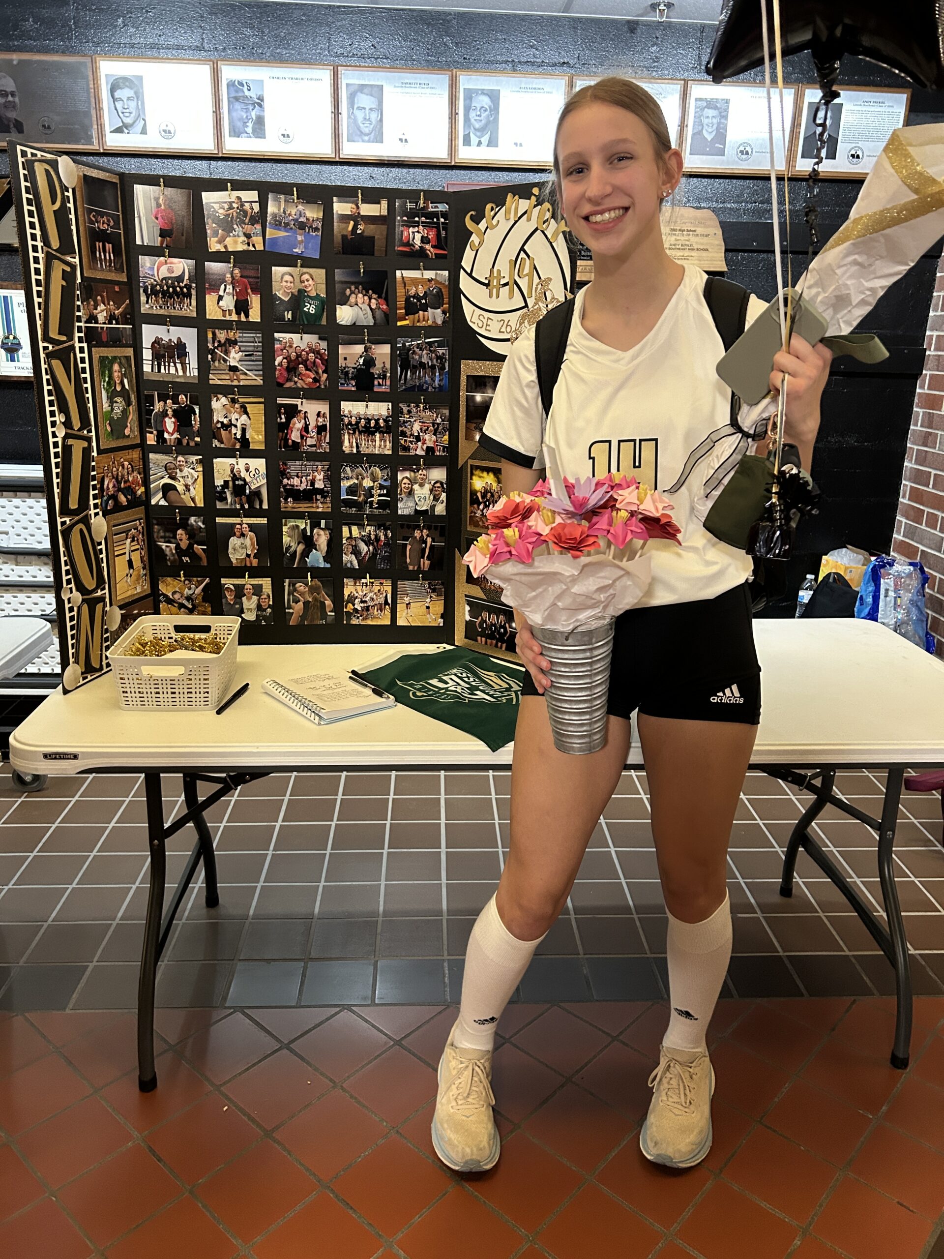 senior vollleybal player with her senior night board