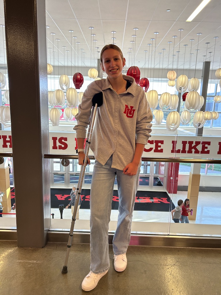 Girl standning in the lobby of Devaney Sports Center for a Husker volleyball game