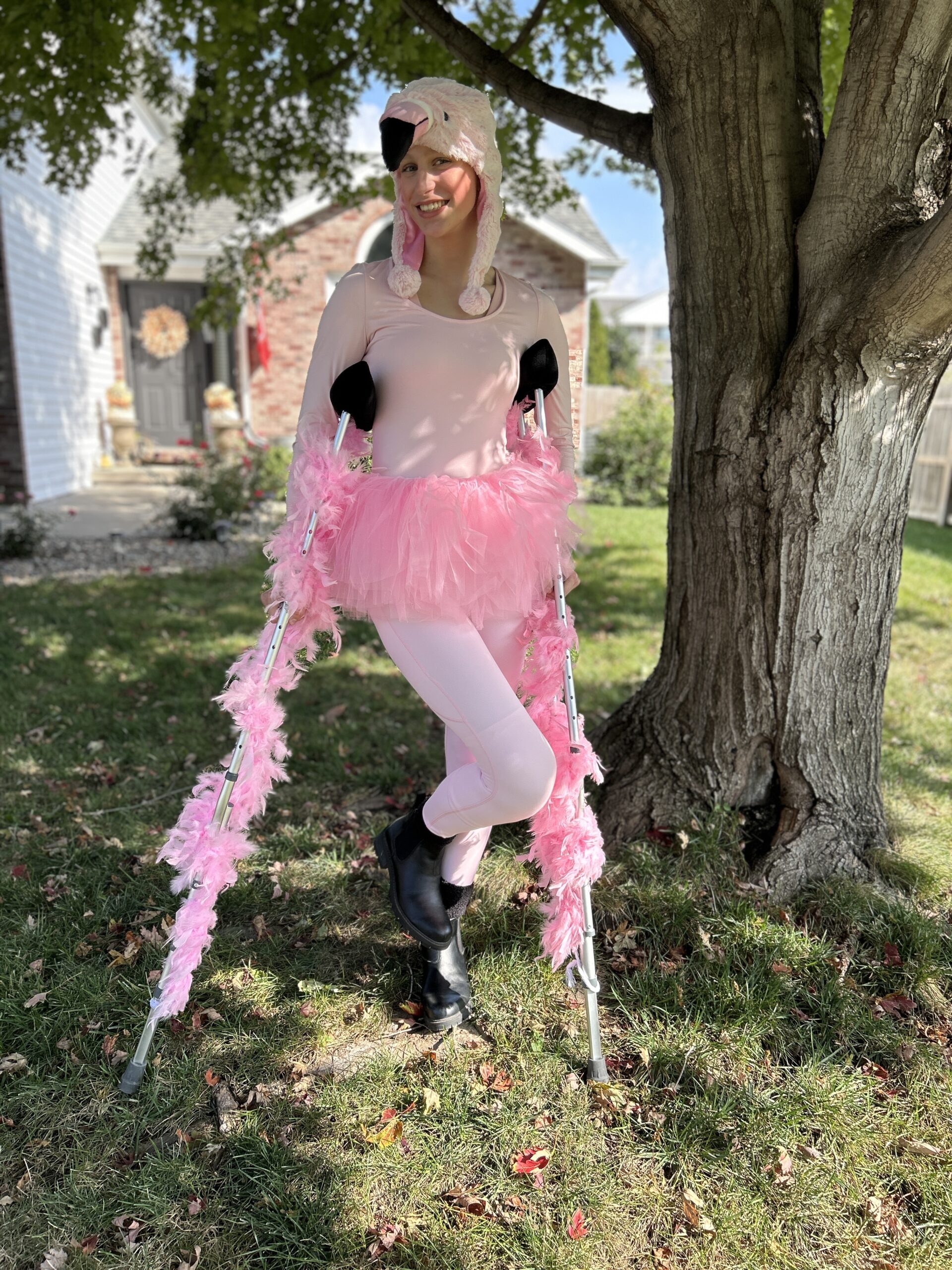 Girl on crutches dressed as a flamingo for Halloween