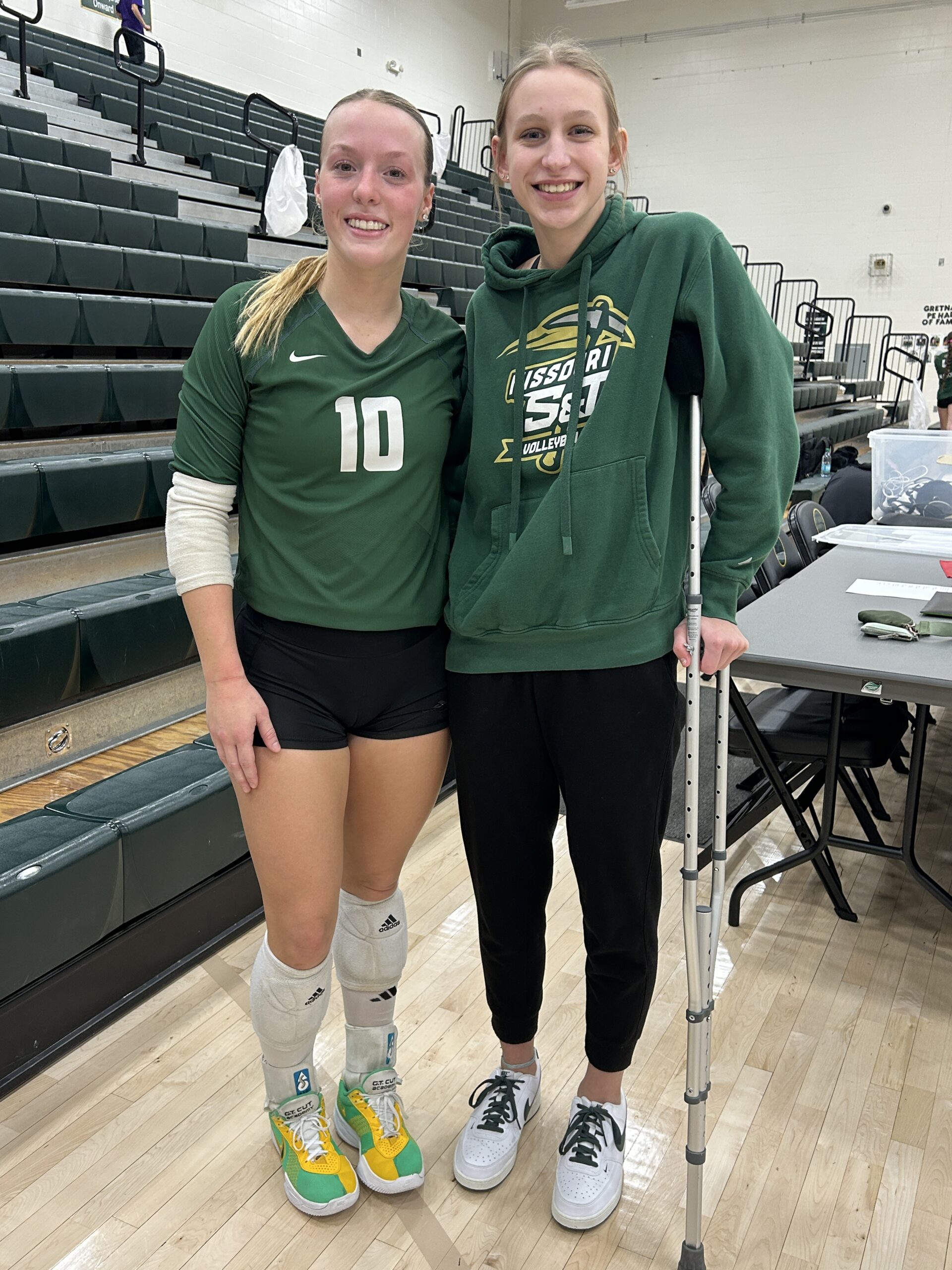 two volleyball players smiling and posing for a picture together