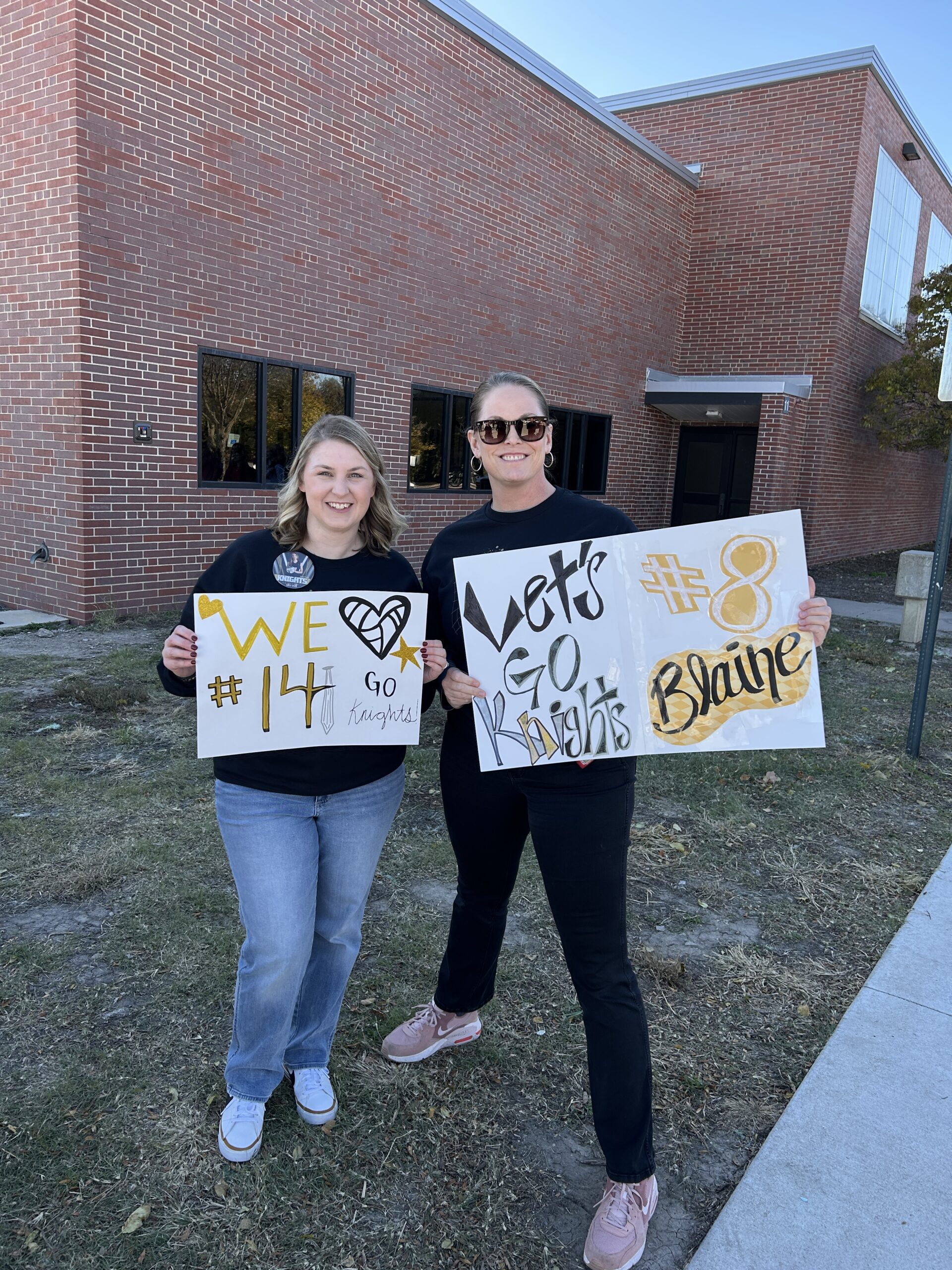 Volleyball moms holding good luck posters for the state tournament