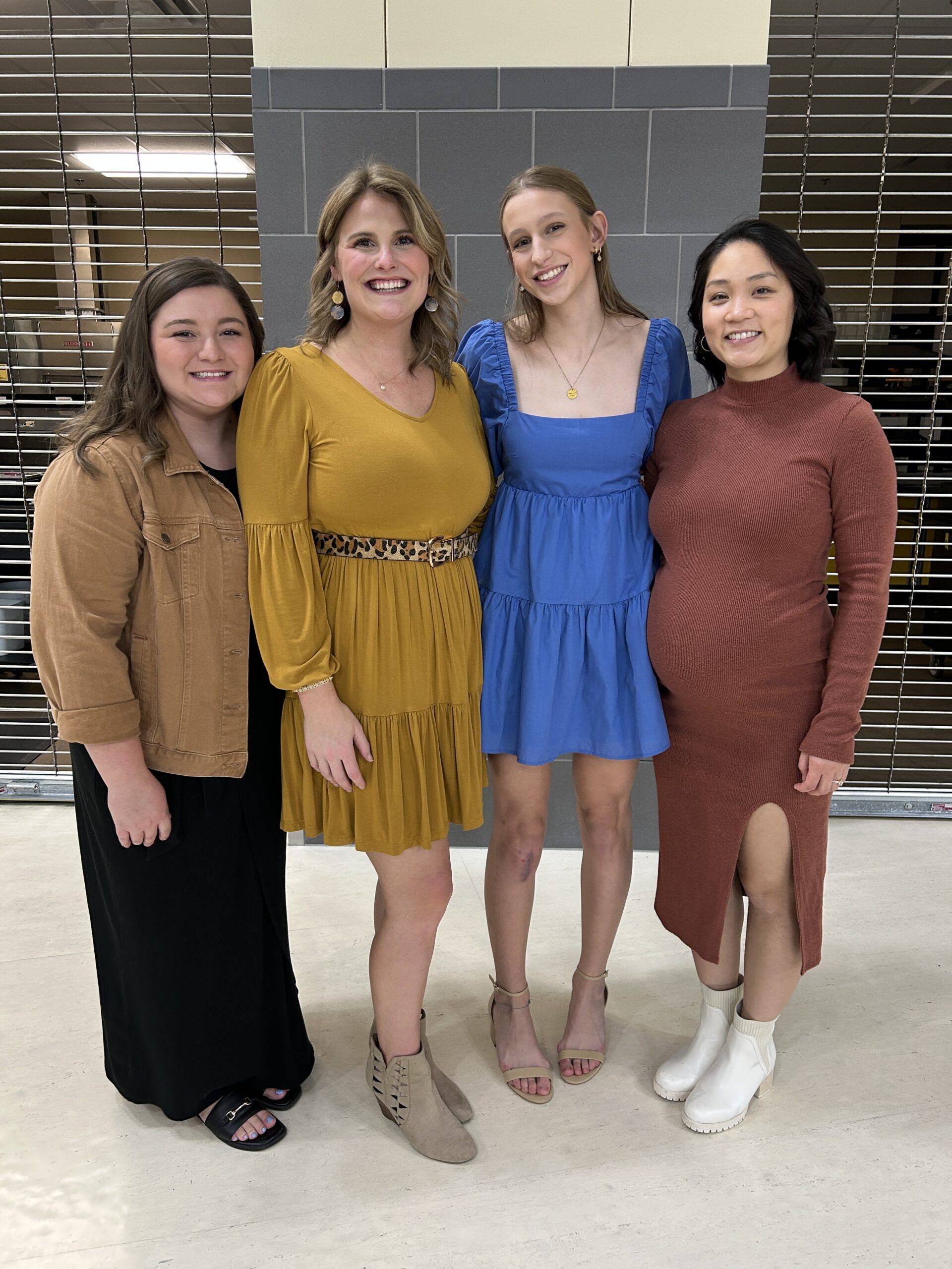 volleybal player smiling and posing for pictures with her coaches at the end of the year banquet