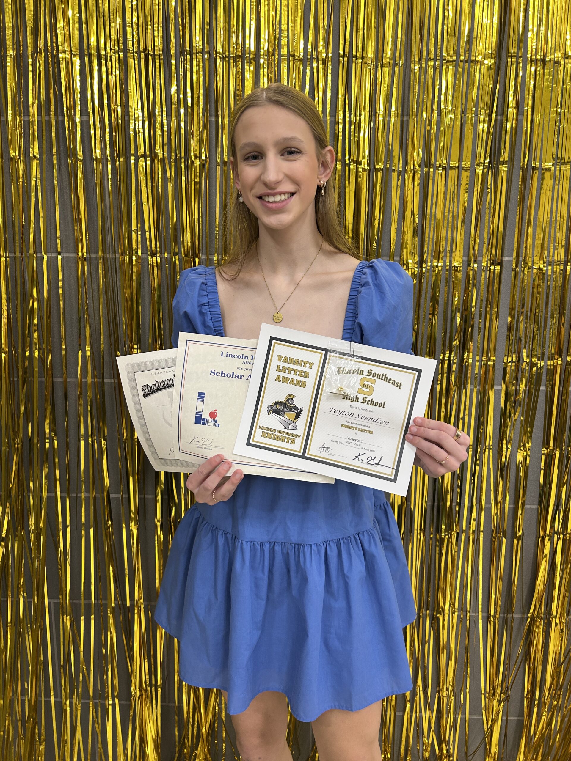 volleyball player holding her awards at the end of the year banquet