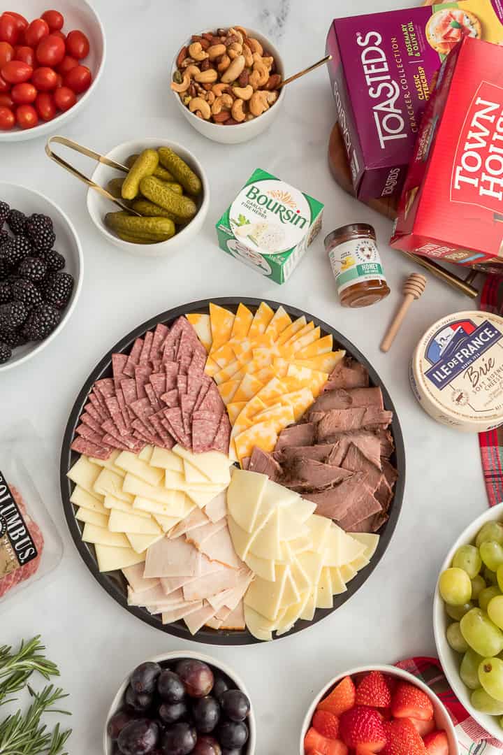 Groceries from Fareway Store with pre-made meat and cheese tray, crackers, and produce to make a Christmas charcuterie board