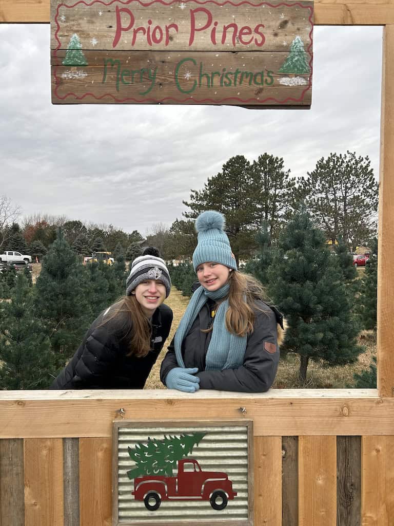 girls smiling at a Christmas tree farm