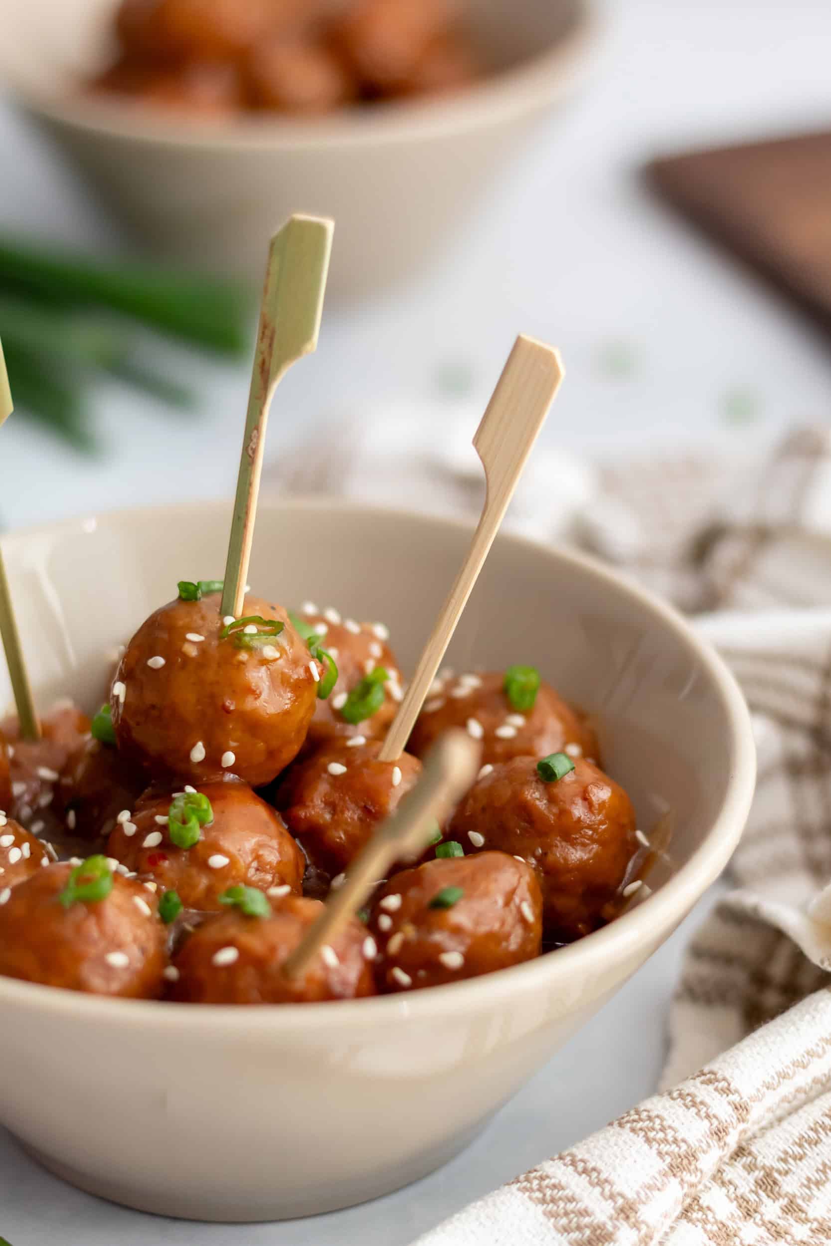 Crockpot teriyaki meatballs served with toothpicks in a bowl, ready for an easy appetizer or party snack.