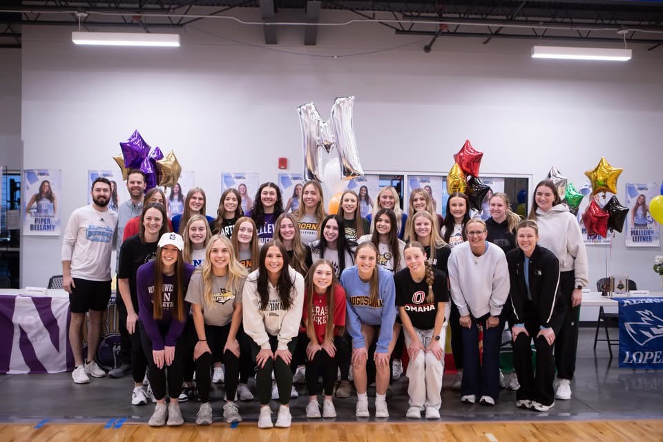 Club volleyball players posing for a group photo during a signing day celebration