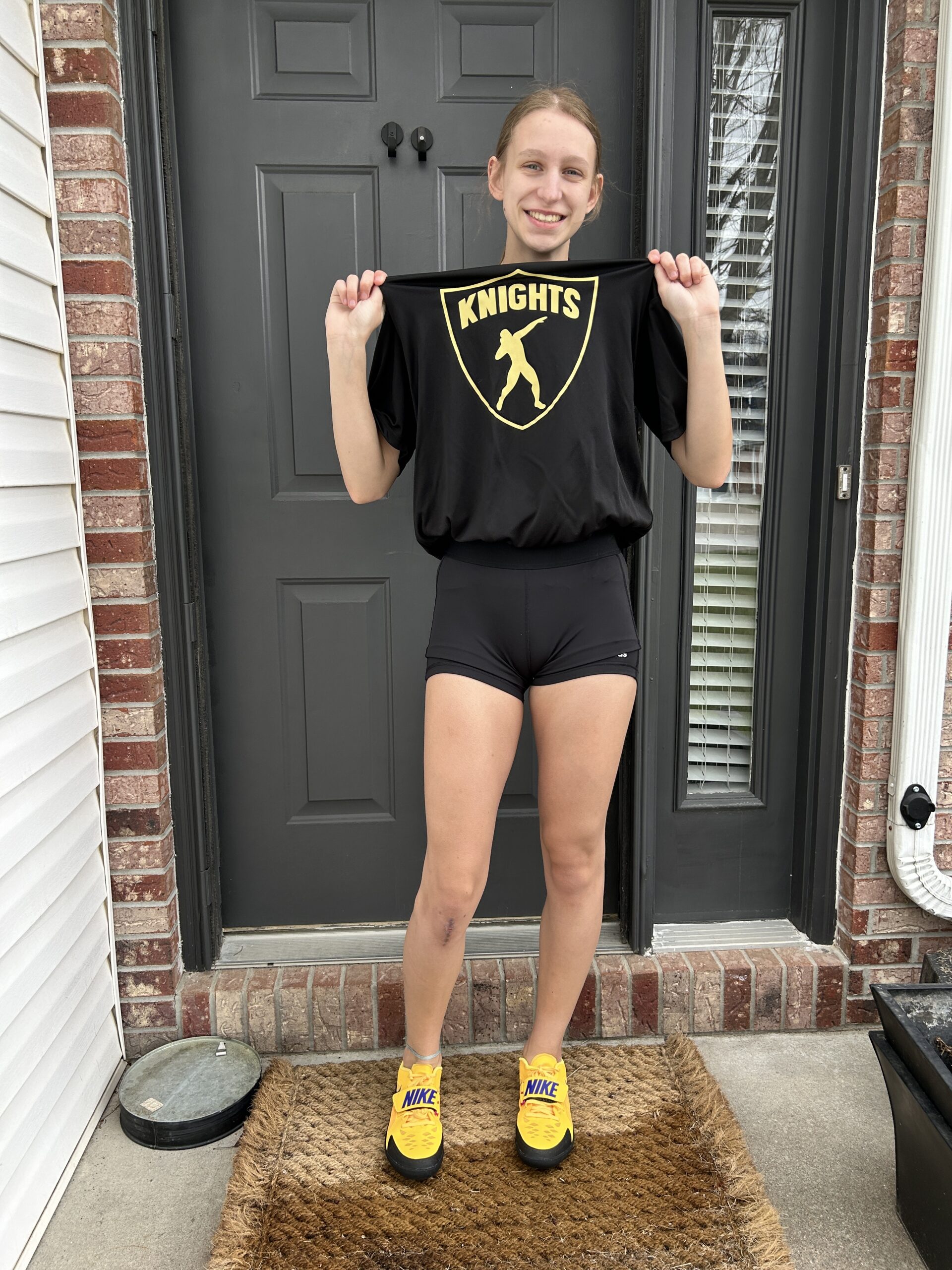 Girl standing and smiling in track uniform