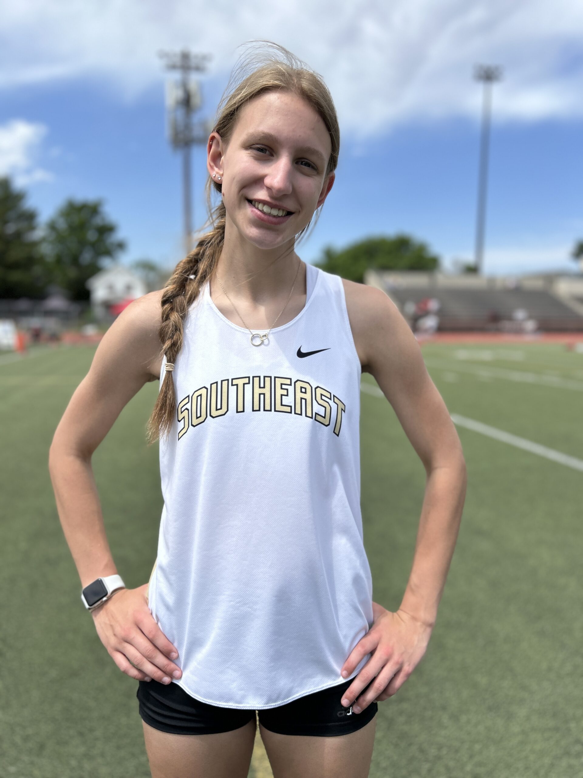 Lincoln Southteast track athlete standing and smiling after competing in the shot put and finishing her senior sports career