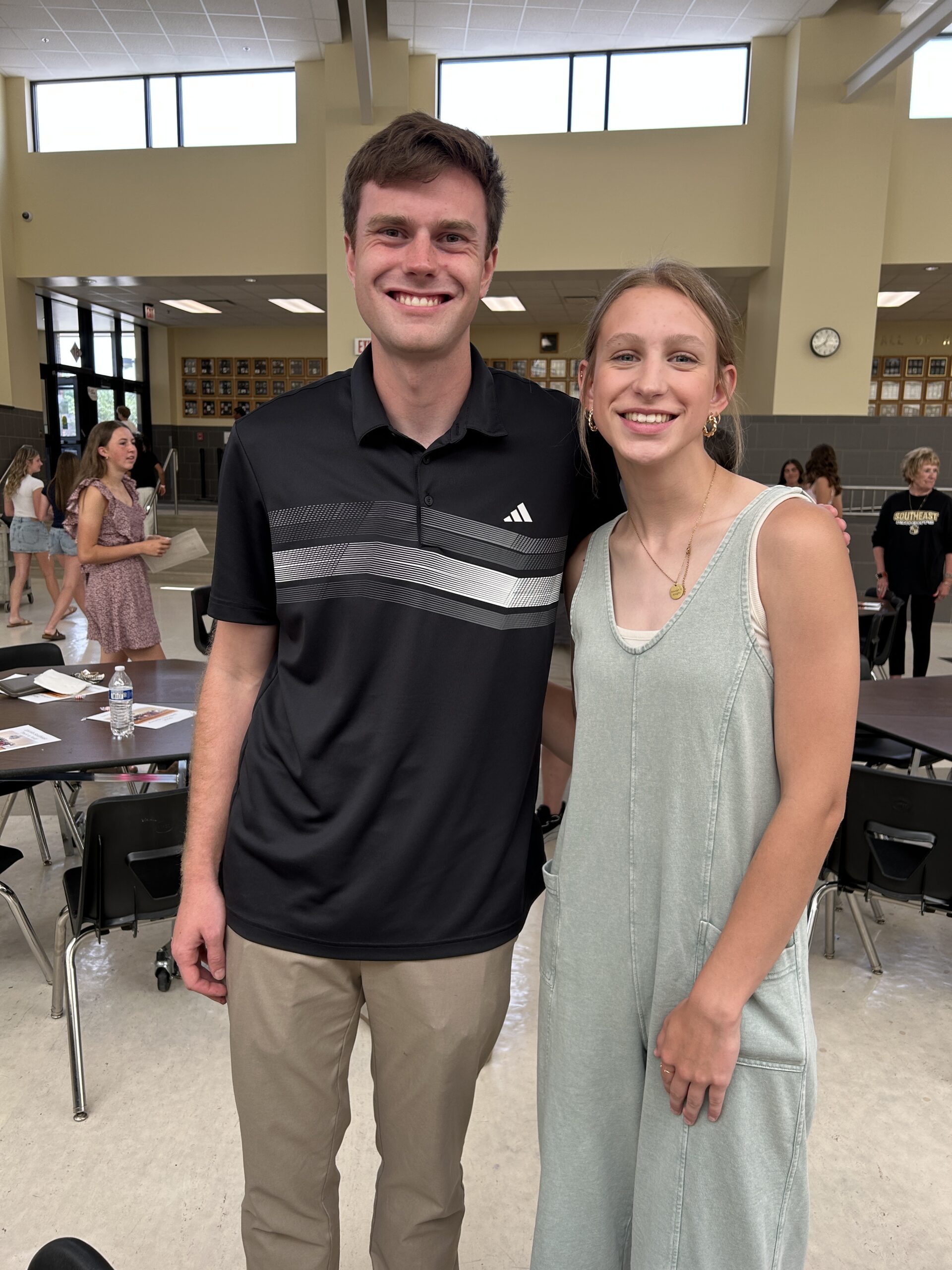 Girl standing and smiling with her track coach at the end of the year awards banquet
