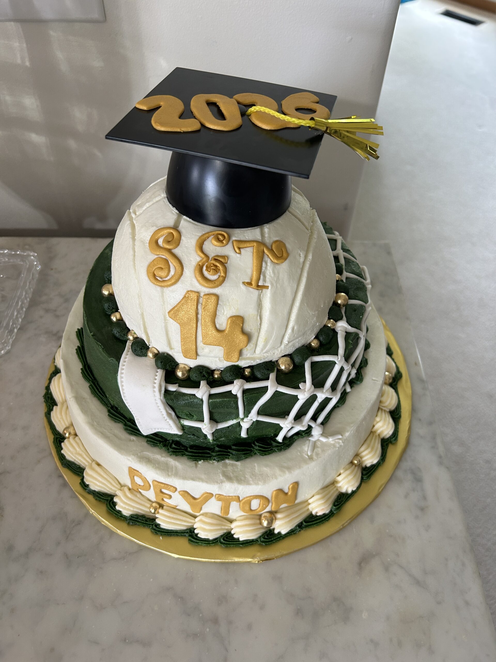 Green and gold 3-tier Missouri S&T volleyball cake with a grad cap and fondant netting made for a graduation party