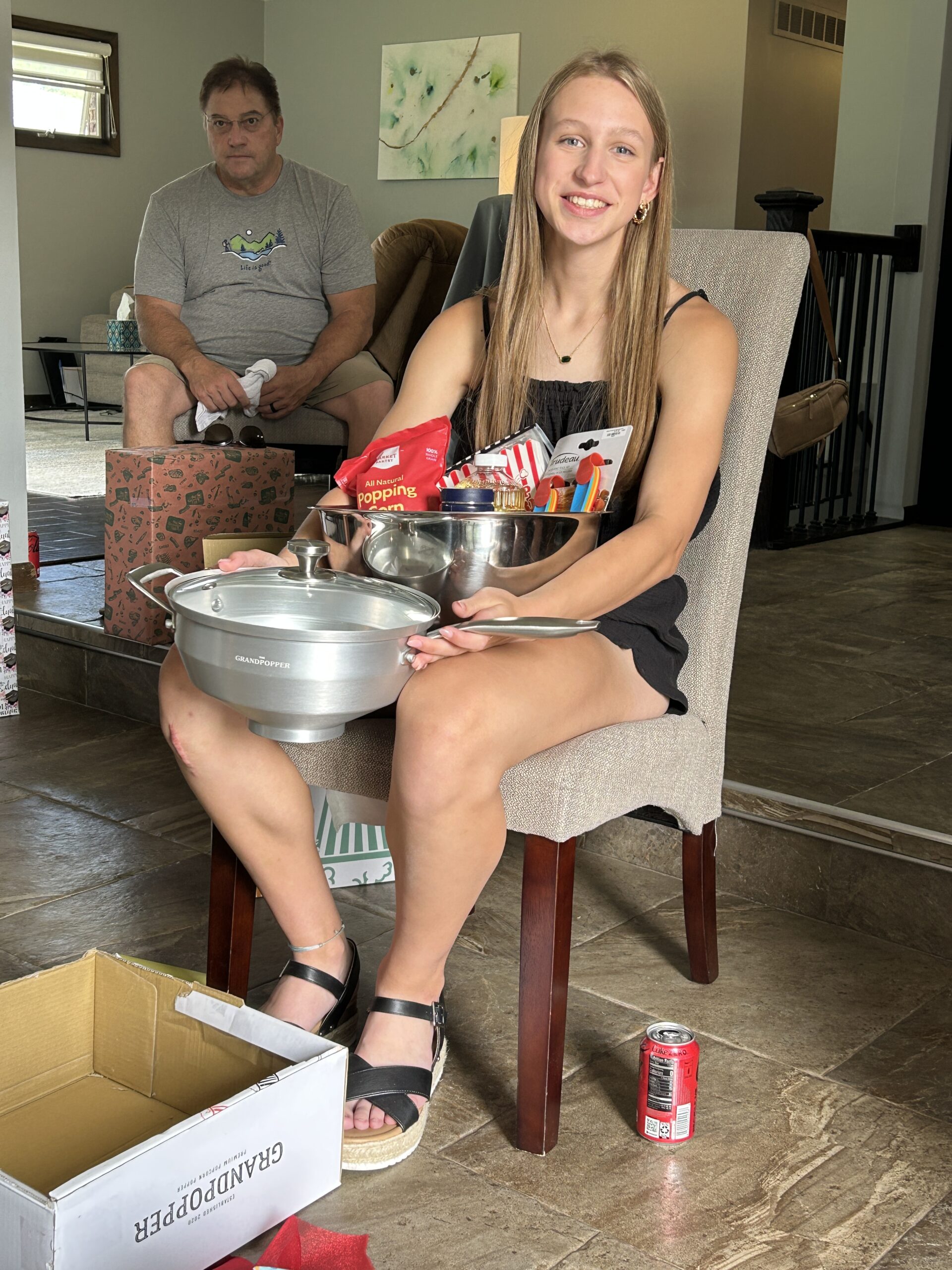 Girl wth some of her graduation gifts including a popcorn popper and supplies to make homemade popcorn