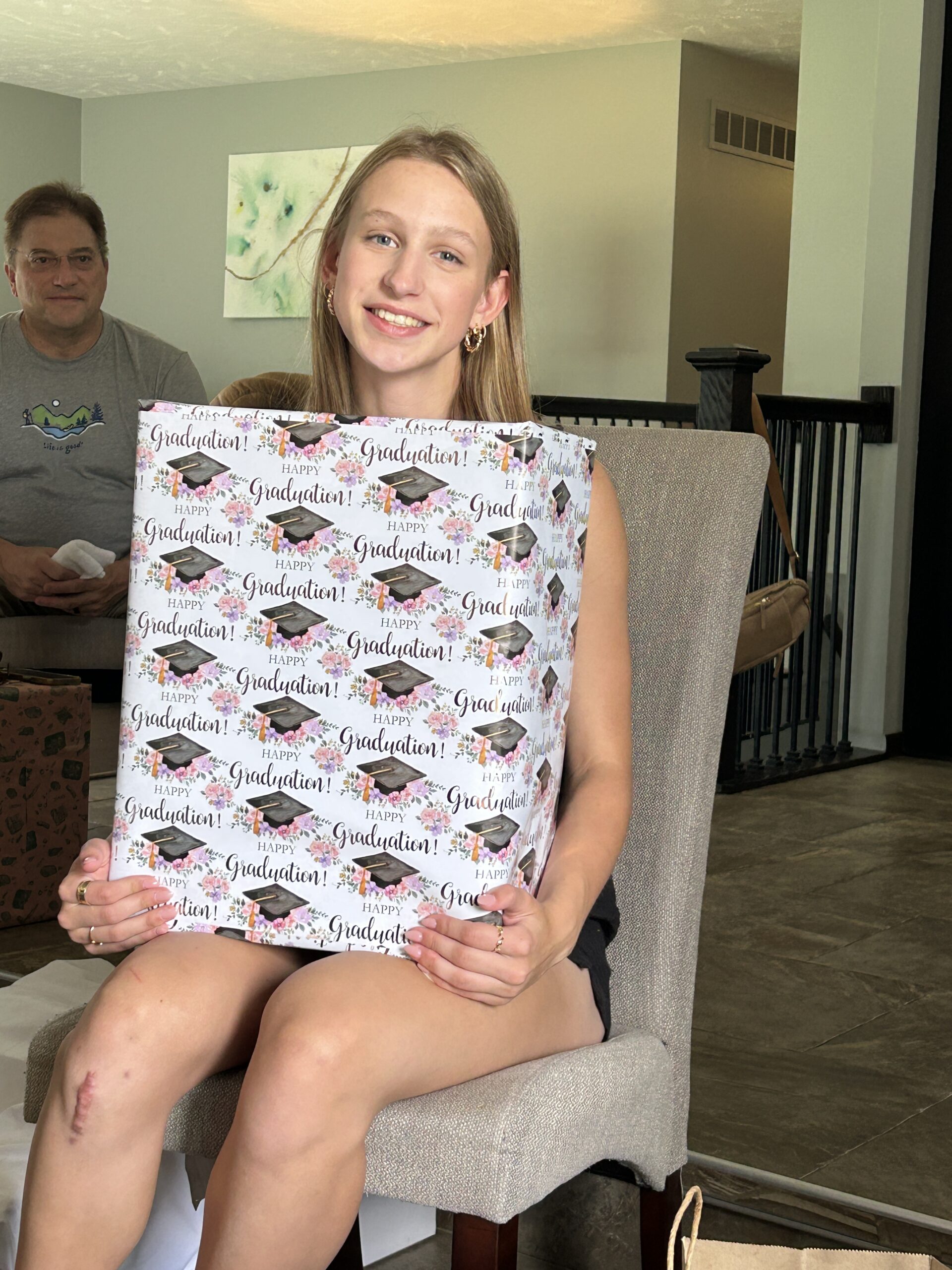 Girl opening graduation gifts
