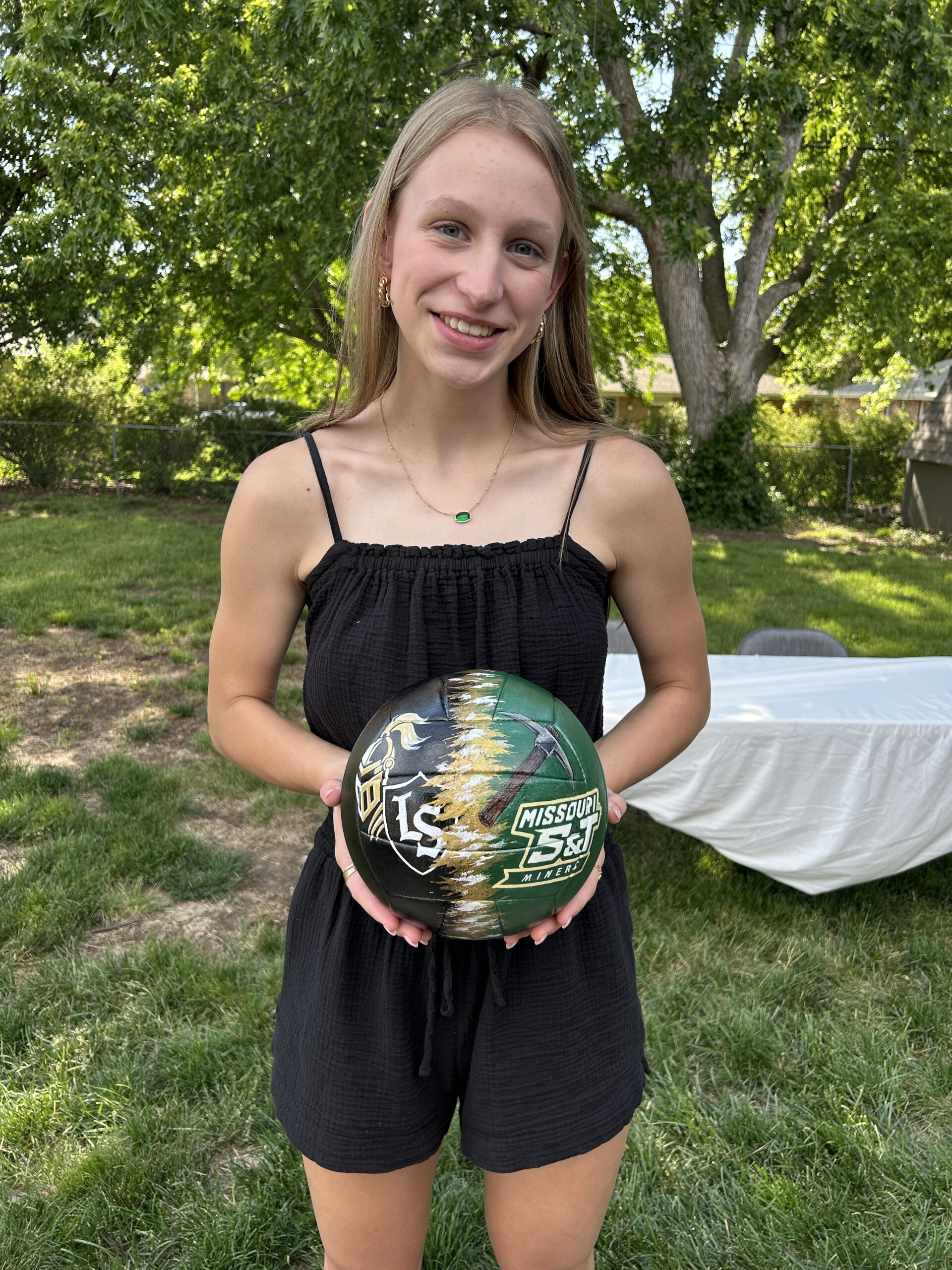 Girl holding custom painted volleyball that she received as a graduatoin gift