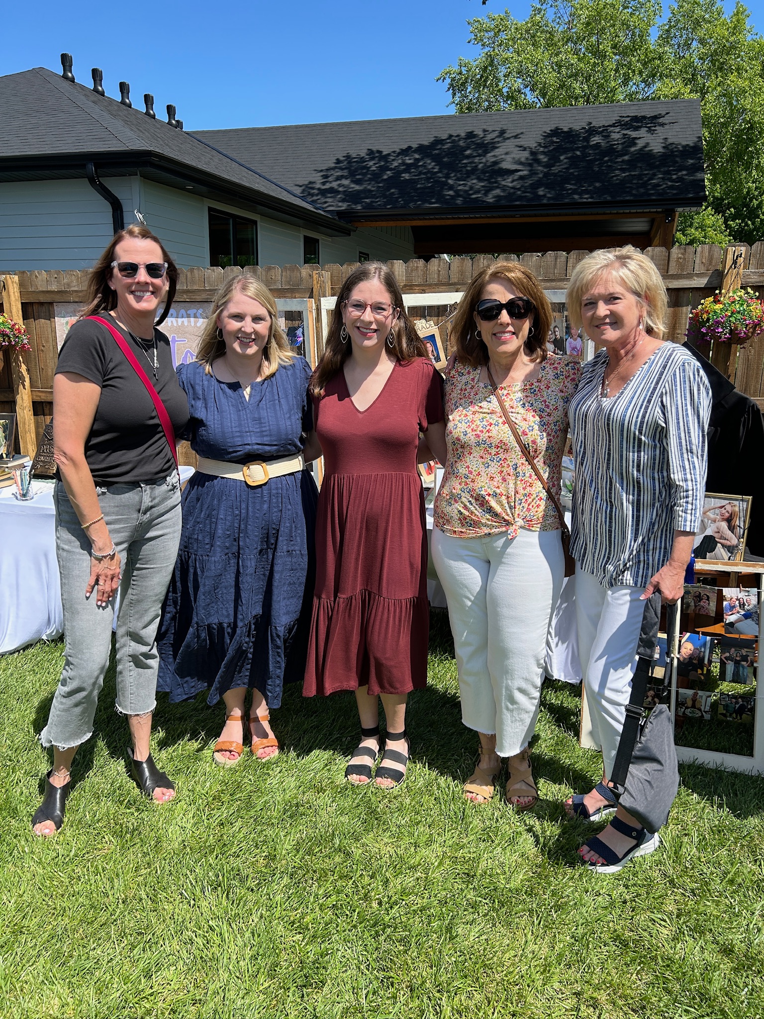 Family friends gathered for a group photo at a backyard high school graduation party.
