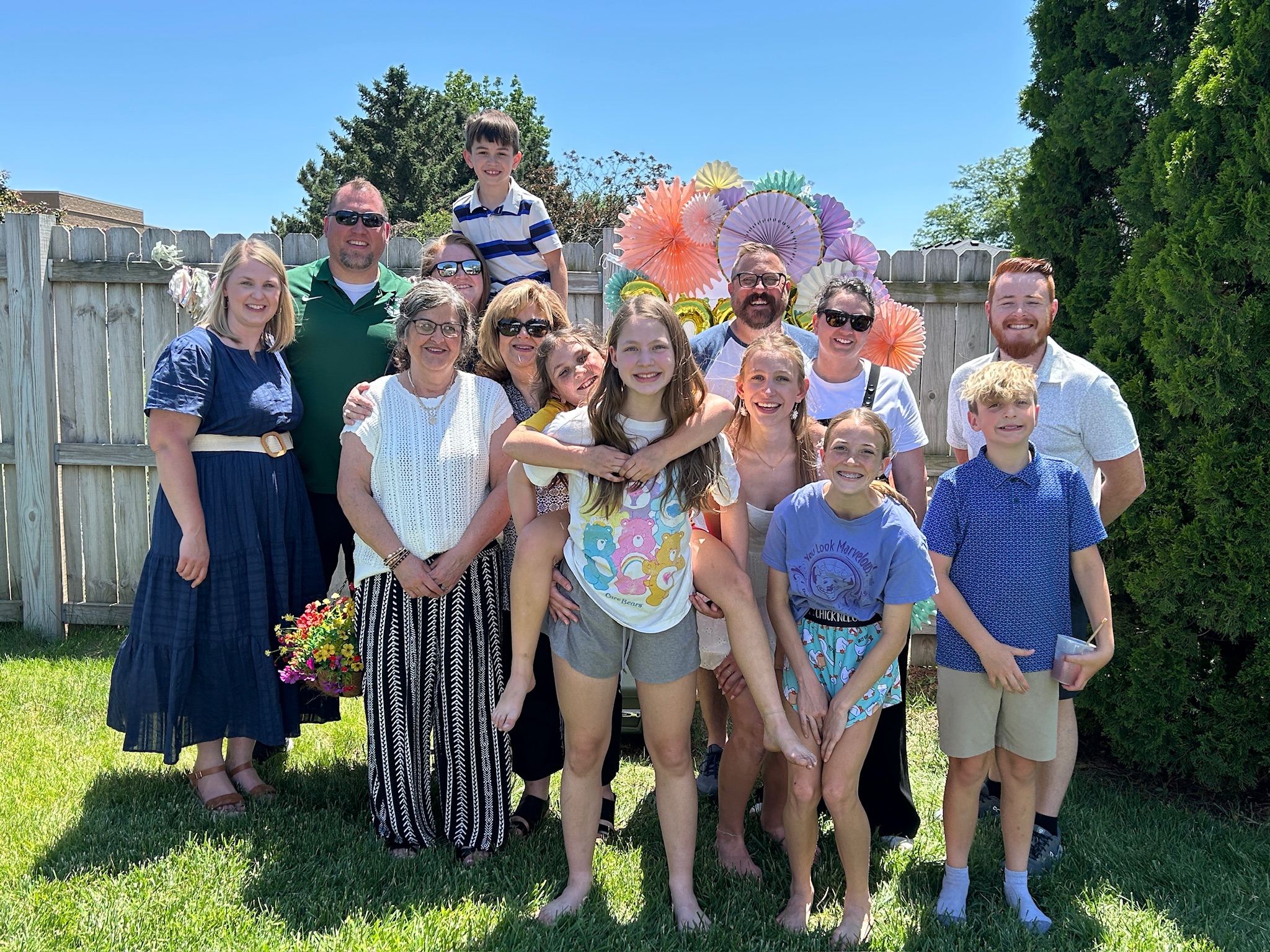 Extended family gathered for a group photo at a backyard high school graduation party.