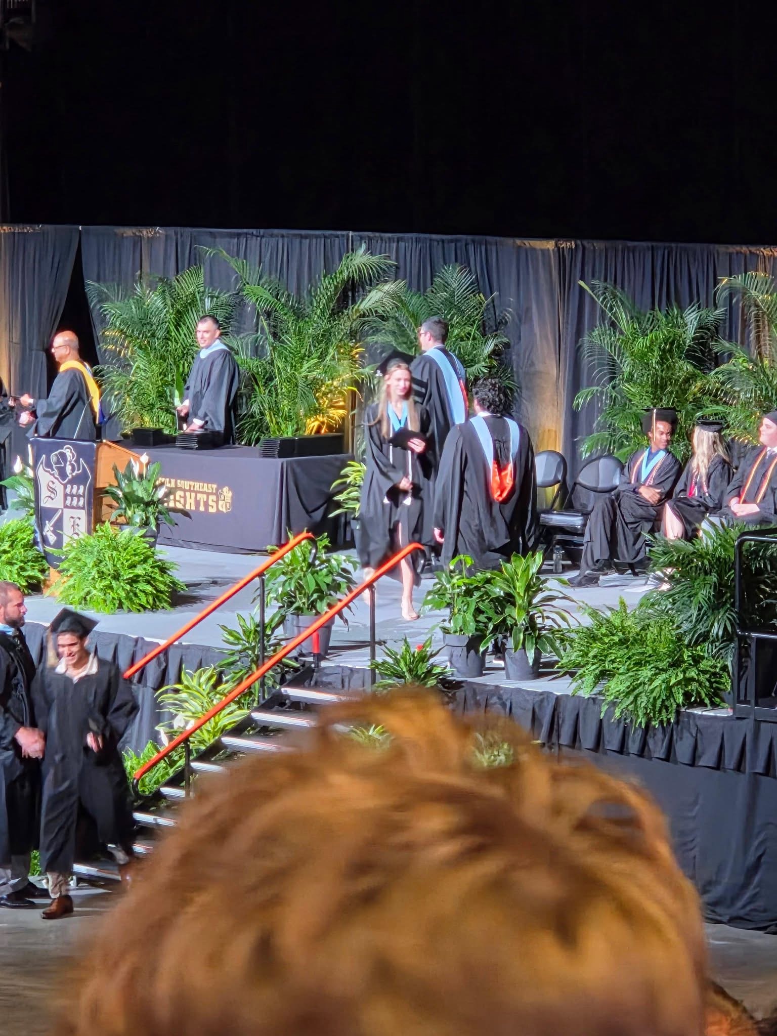 Photo of the graduate walking acorss the stage receiving her diploma
