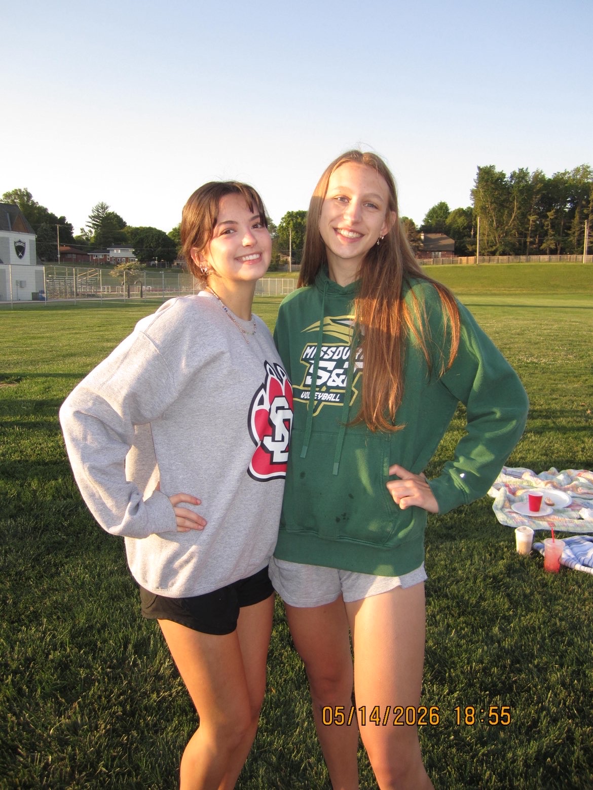 Friends smiling and taking photos in their college gear for senior sunrise
