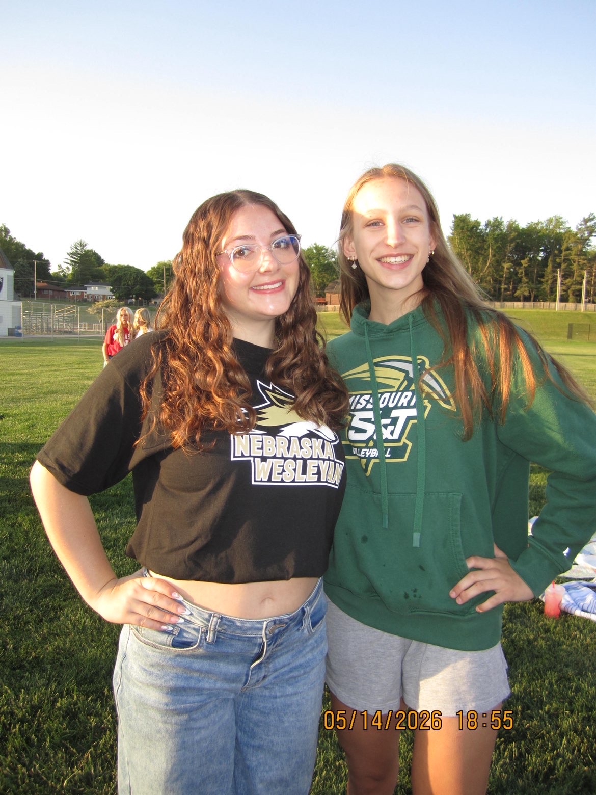 Friends smiling and taking photos in their college gear for senior sunrise