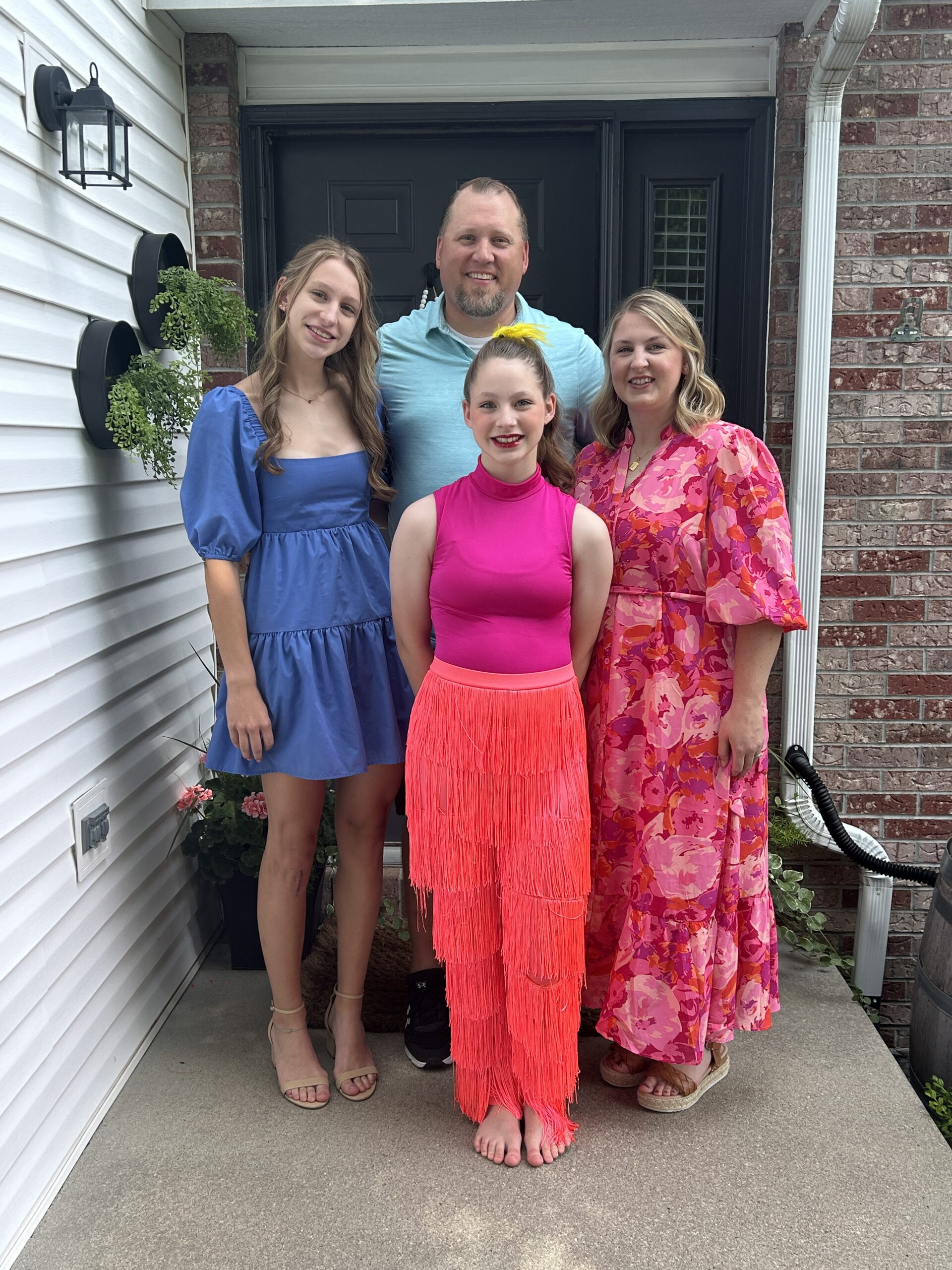 Family standing and smiling ready for a dance recital