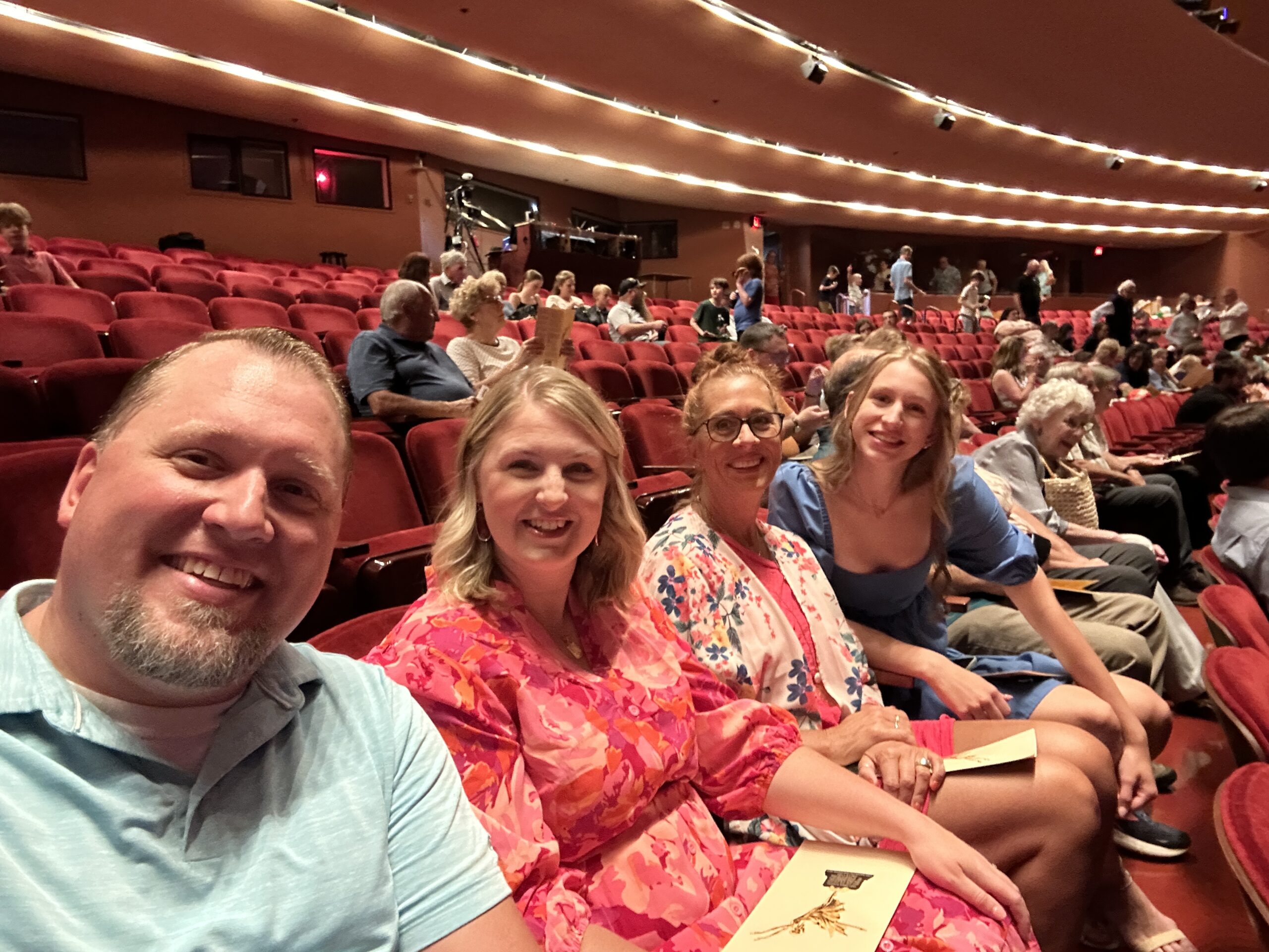 Family seated in a theatre ready to watch a dance recital