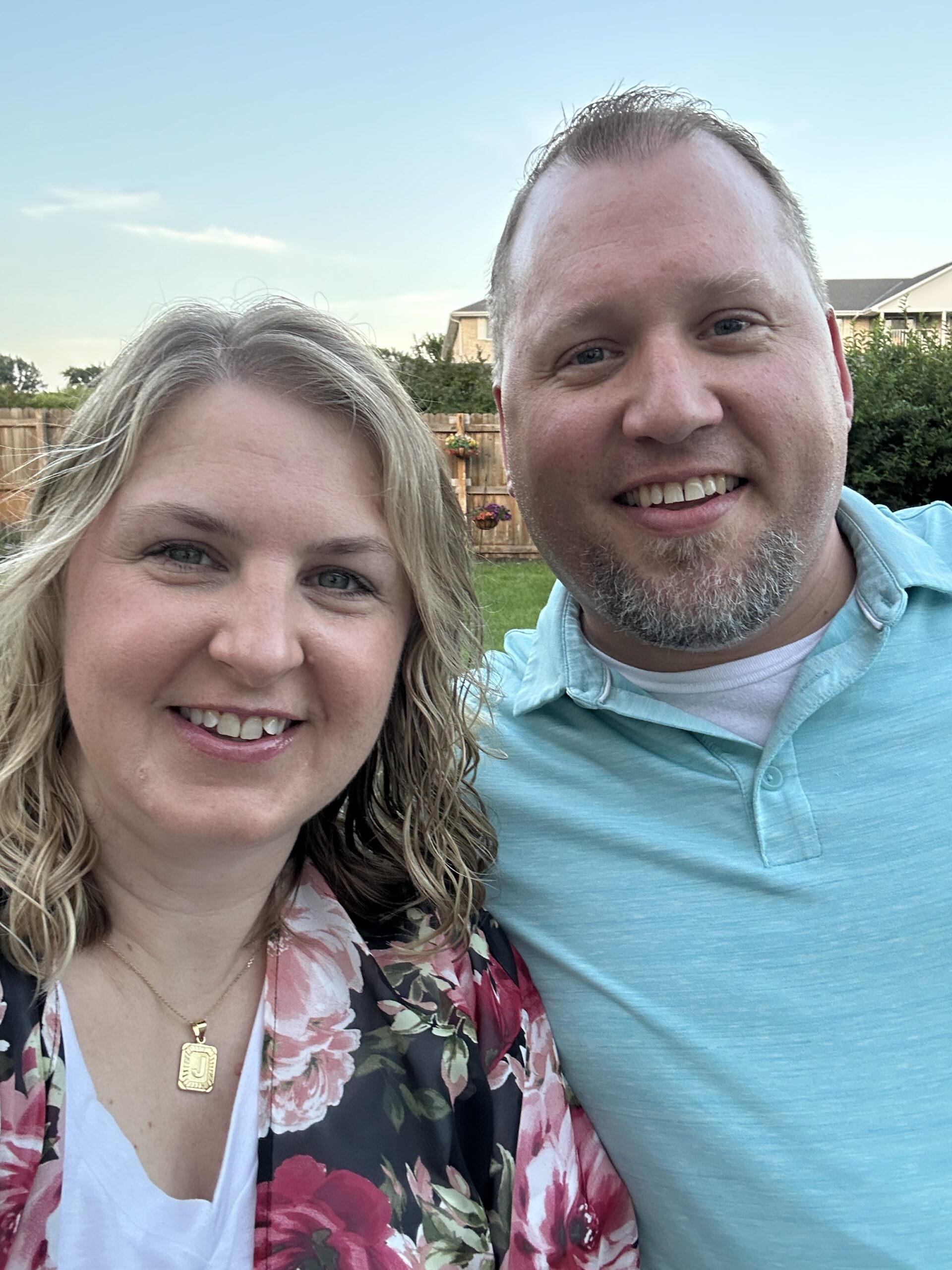 Couple smiling for a selfie taken in their backyard after an anniversary dinner date