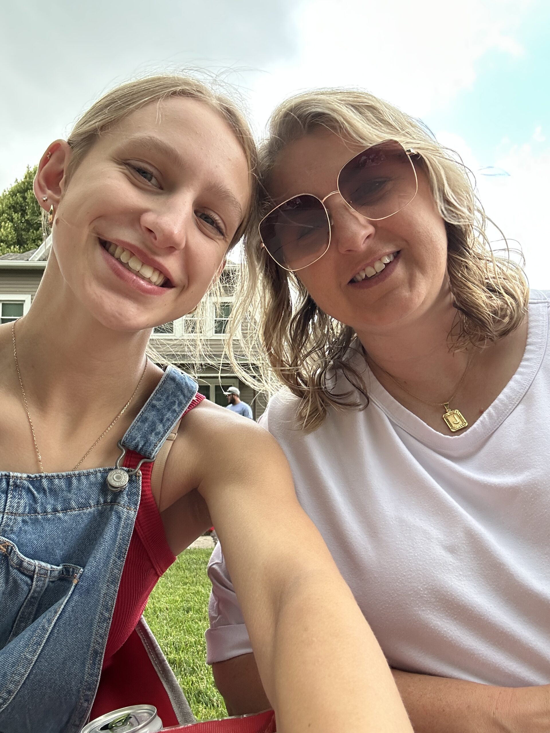 A mother and daughter smiling for a selfie at a 4th of July parade