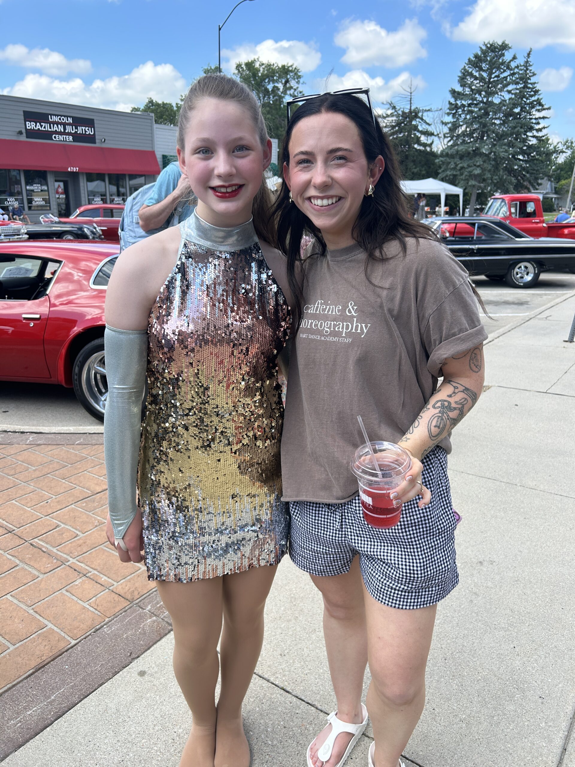 Dancer posing with her dance instructor after a parade performance.