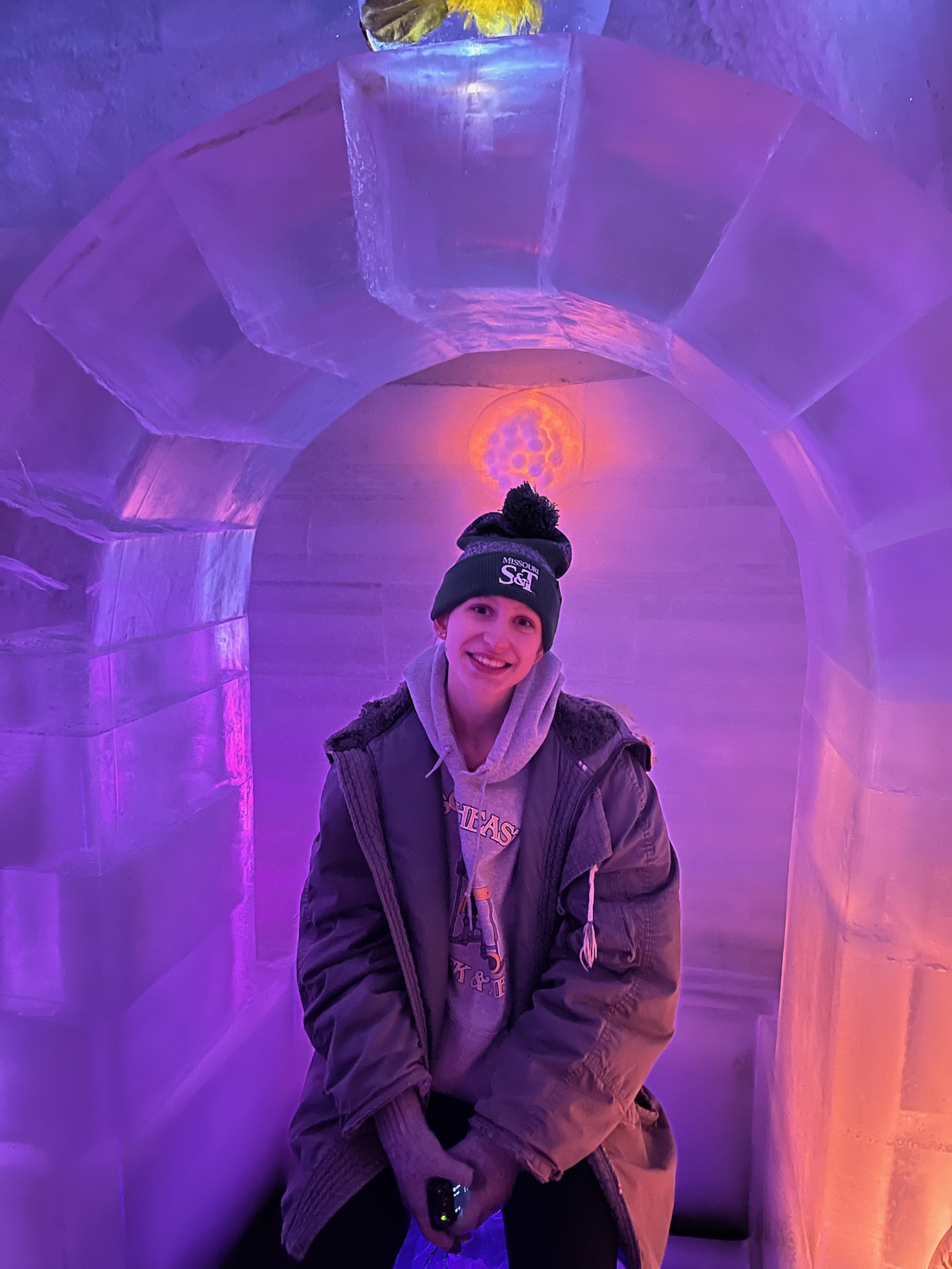Girl sitting and smiling visiting an ice museum in Alaska