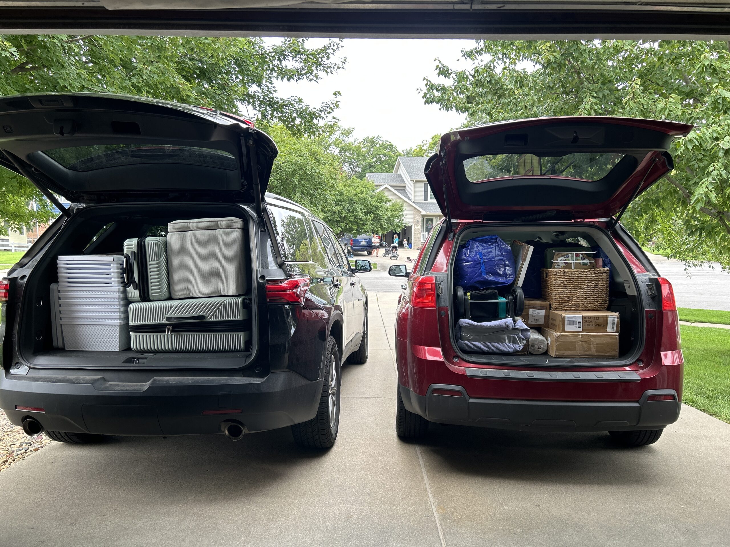 Two SUVs packed with suitcases, storage bins, boxes, and other supplies for college move-in day.