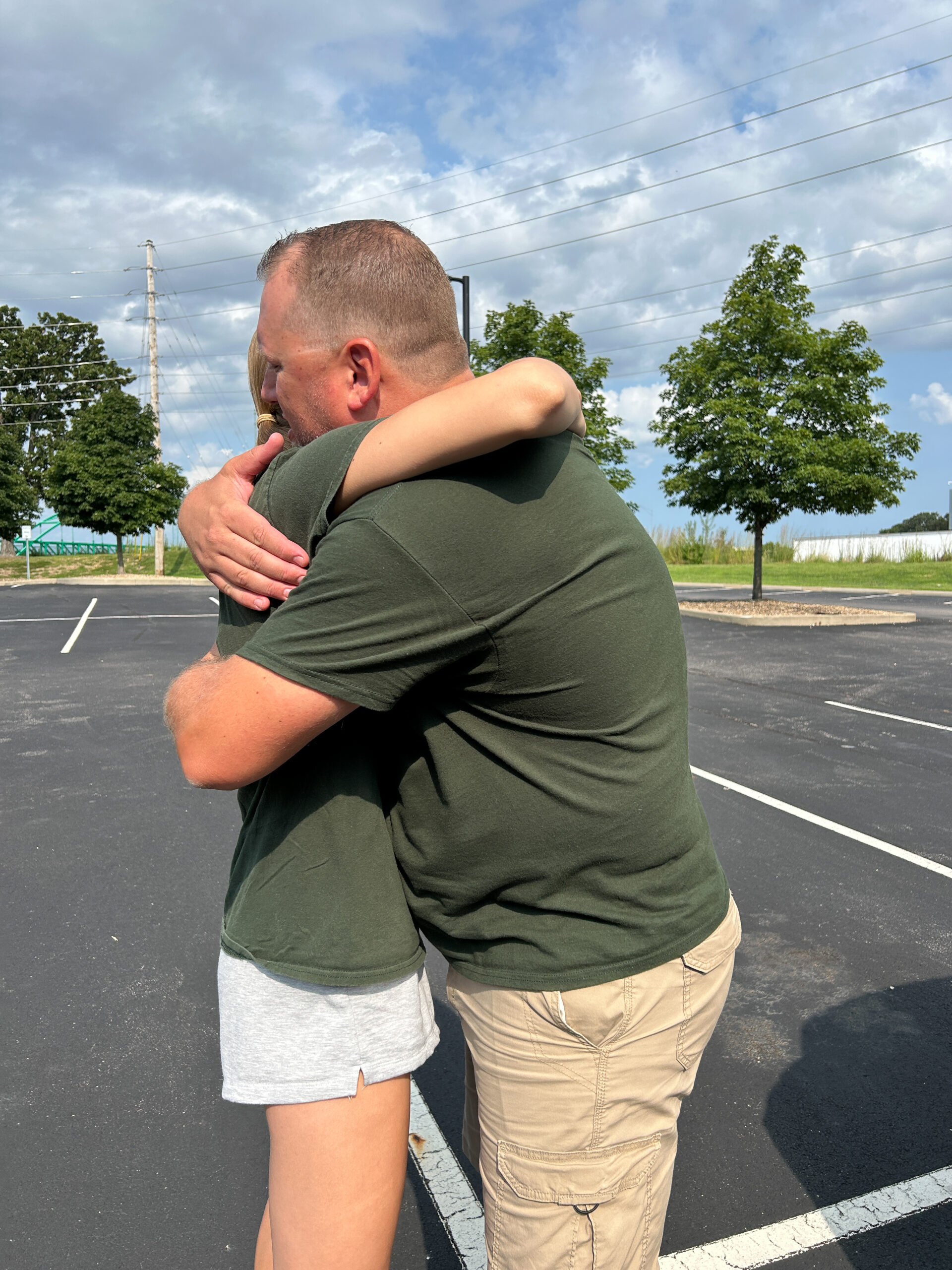 Dad and daughter share a goodbye hug in the parking lot after college move-in day.