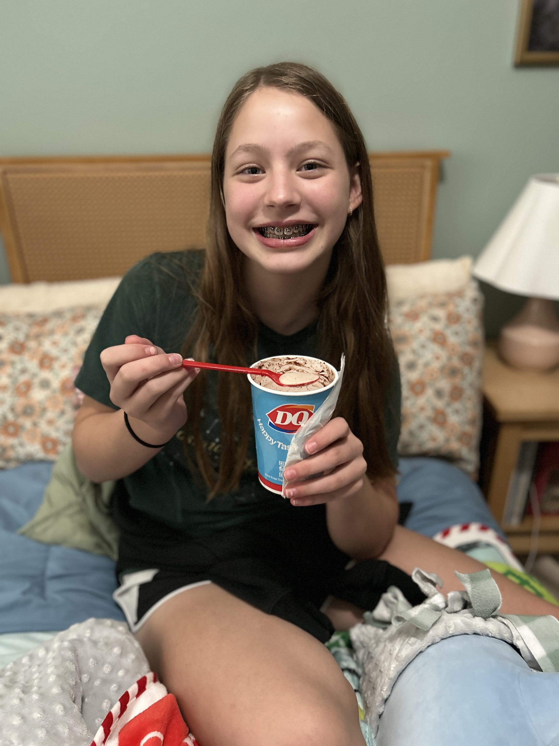 Young girl smiling with her new braces while enjoying a Dairy Queen Blizzard.