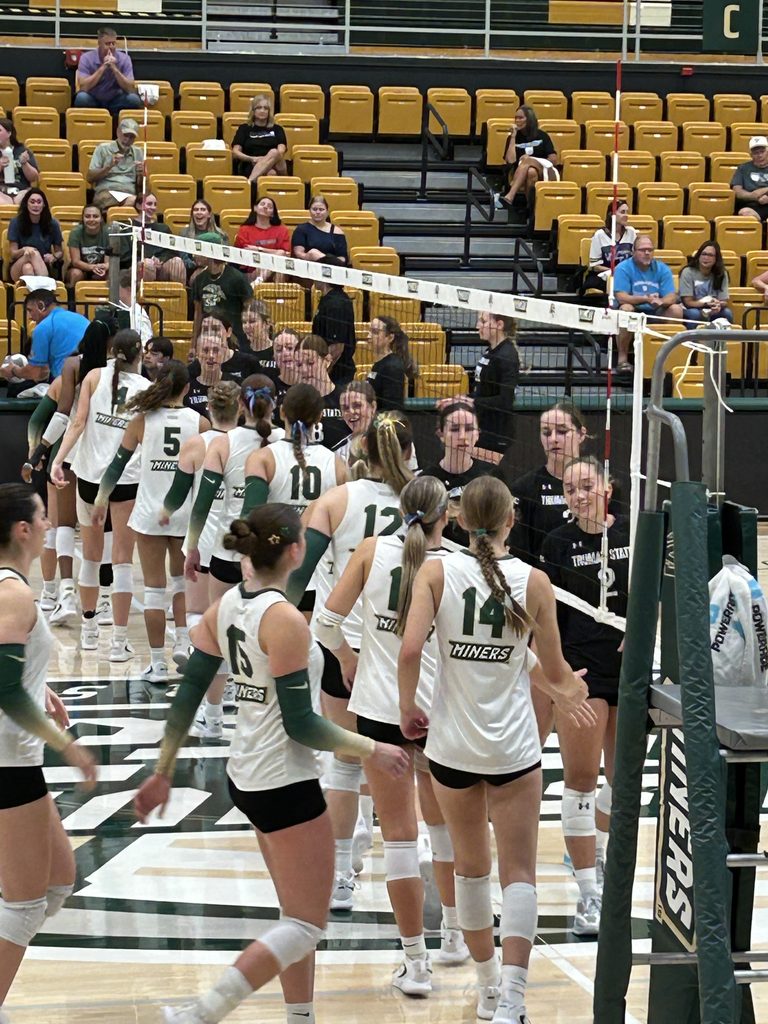 Missouri S&T volleyball players greeting the opposing team at the net before a home match.