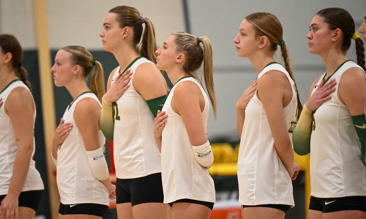 Missouri S&T volleyball players standing together on the court before a match.