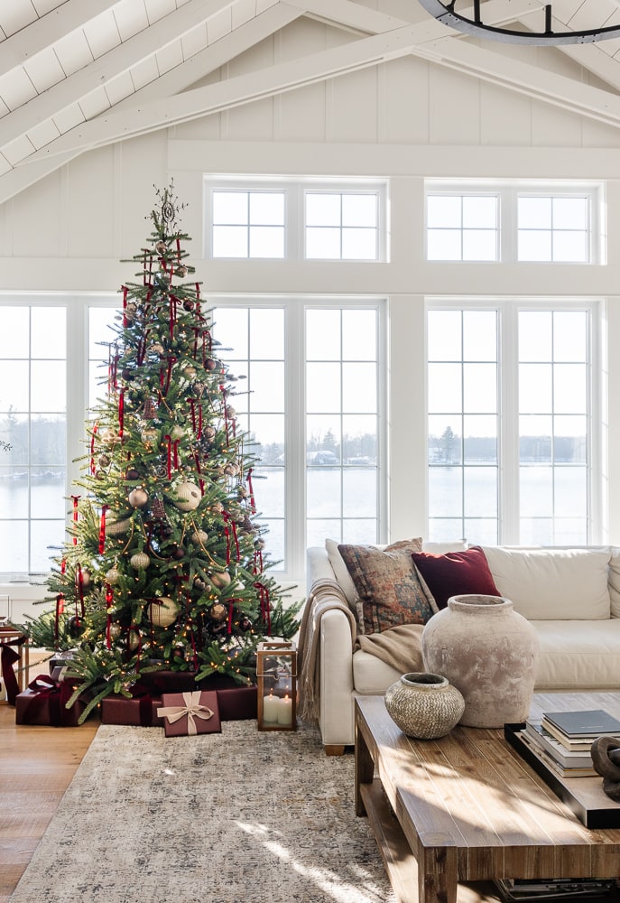 Burgundy and gold holiday color palette with a Christmas tree decorated with burgundy ribbon, gold ornaments, and coordinating wrapped gifts.