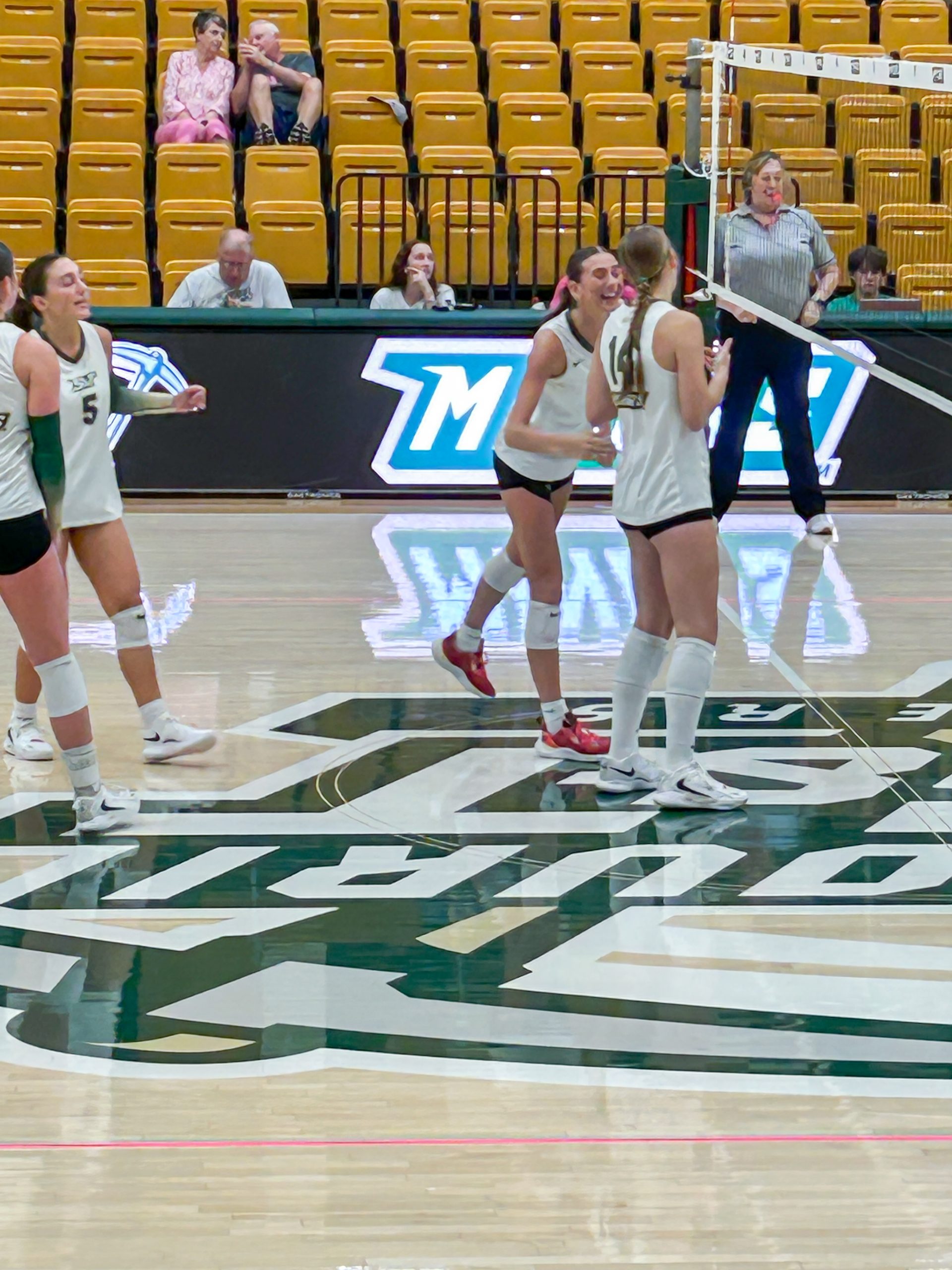 Peyton Svendsen, wearing jersey number 14, smiles and celebrates with a teammate during a Missouri S&T volleyball match.